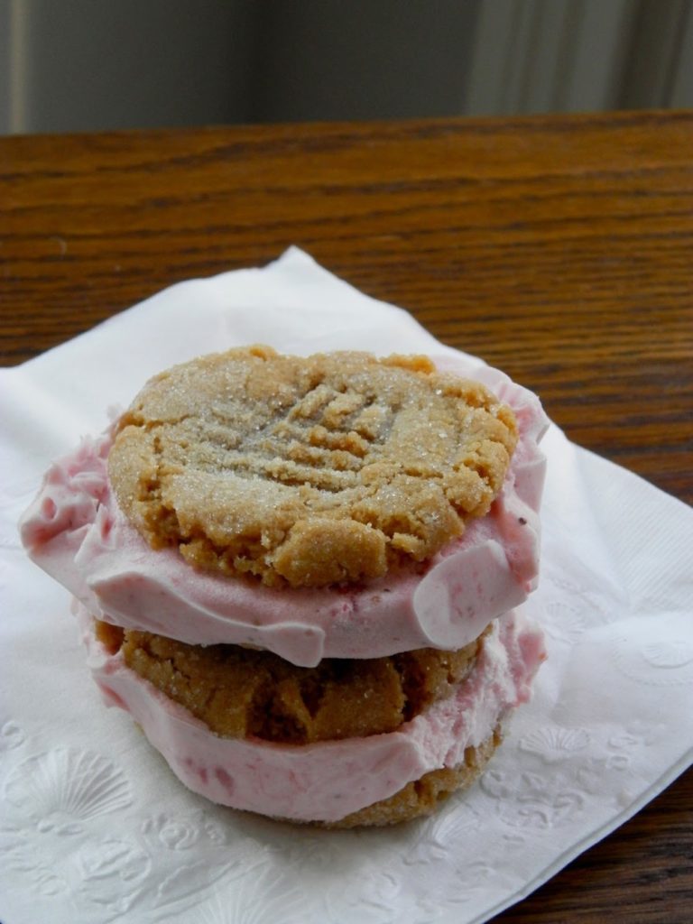Peanut Butter and Jelly Ice Cream Sandwiches - sweet strawberry ice cream sandwiched between two peanut butter cookies #icecreamsandwich #peanutbutterandjelly | www.thebatterthickens.com