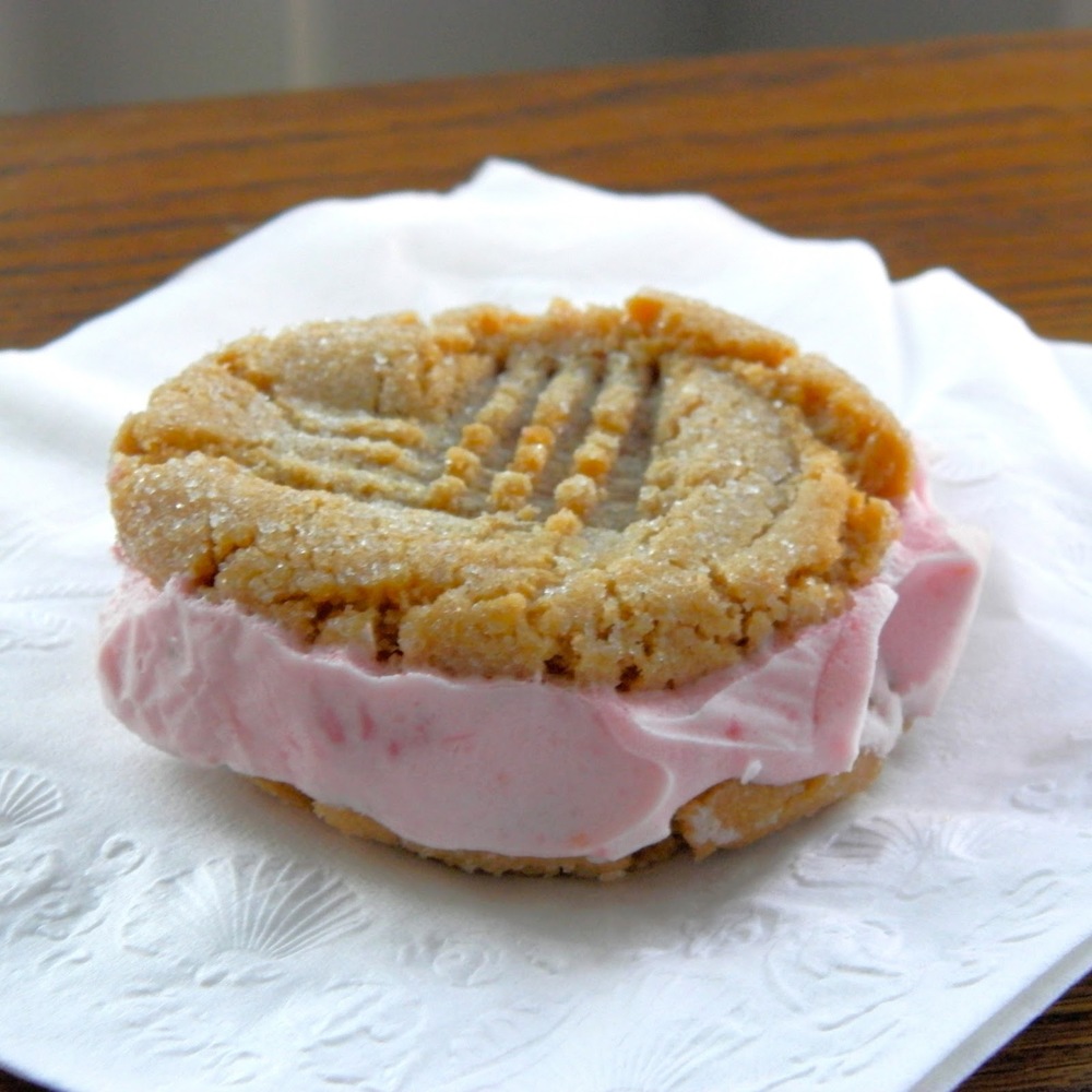 Peanut Butter and Jelly Ice Cream Sandwiches - sweet strawberry ice cream sandwiched between two peanut butter cookies #icecreamsandwich #peanutbutterandjelly | www.thebatterthickens.com