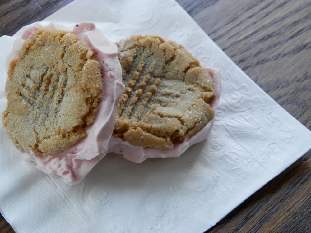 Peanut Butter and Jelly Ice Cream Sandwiches - sweet strawberry ice cream sandwiched between two peanut butter cookies #icecreamsandwich #peanutbutterandjelly | www.thebatterthickens.com