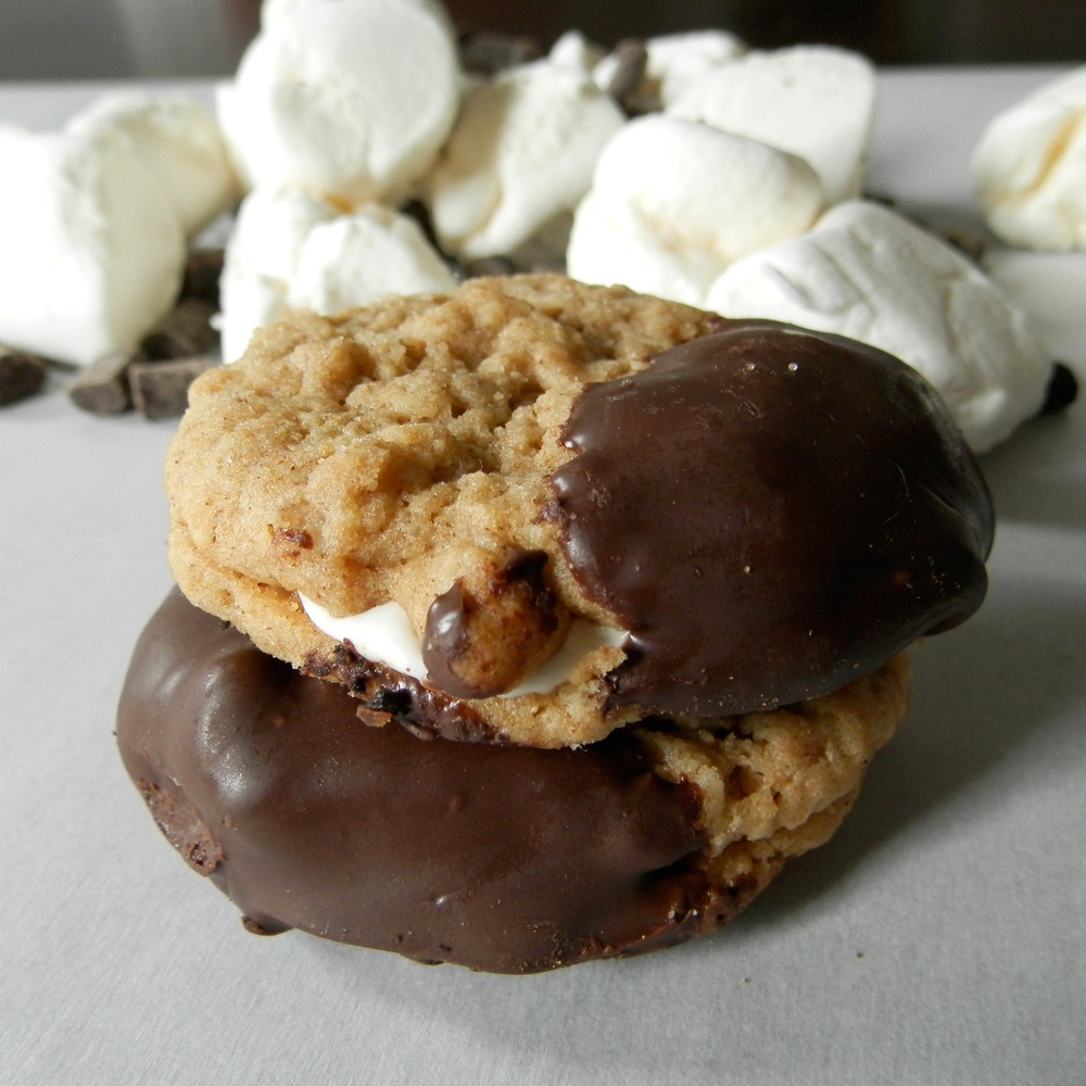 Peanut Butter S'mores Cookie Sandwiches - peanut butter cookies made with homemade peanut butter, sandwiched around marshmallow fluff, dipped in chocolate #smores #cookiesandwich #peanutbutter | www.thebatterthickens.com