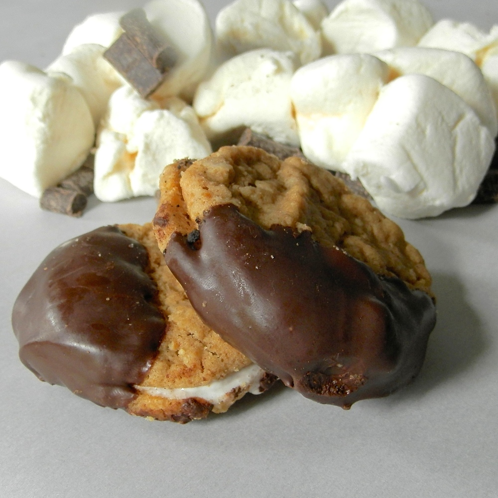 Peanut Butter S'mores Cookie Sandwiches - peanut butter cookies made with homemade peanut butter, sandwiched around marshmallow fluff, dipped in chocolate #smores #cookiesandwich #peanutbutter | www.thebatterthickens.com