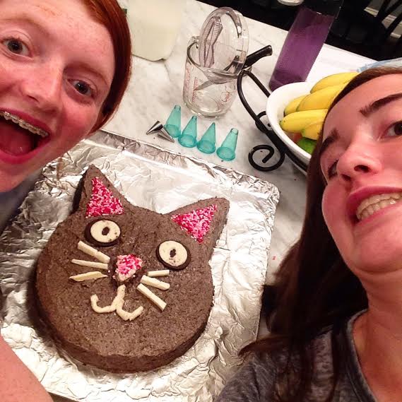 Funfetti cat cake with two girls posing