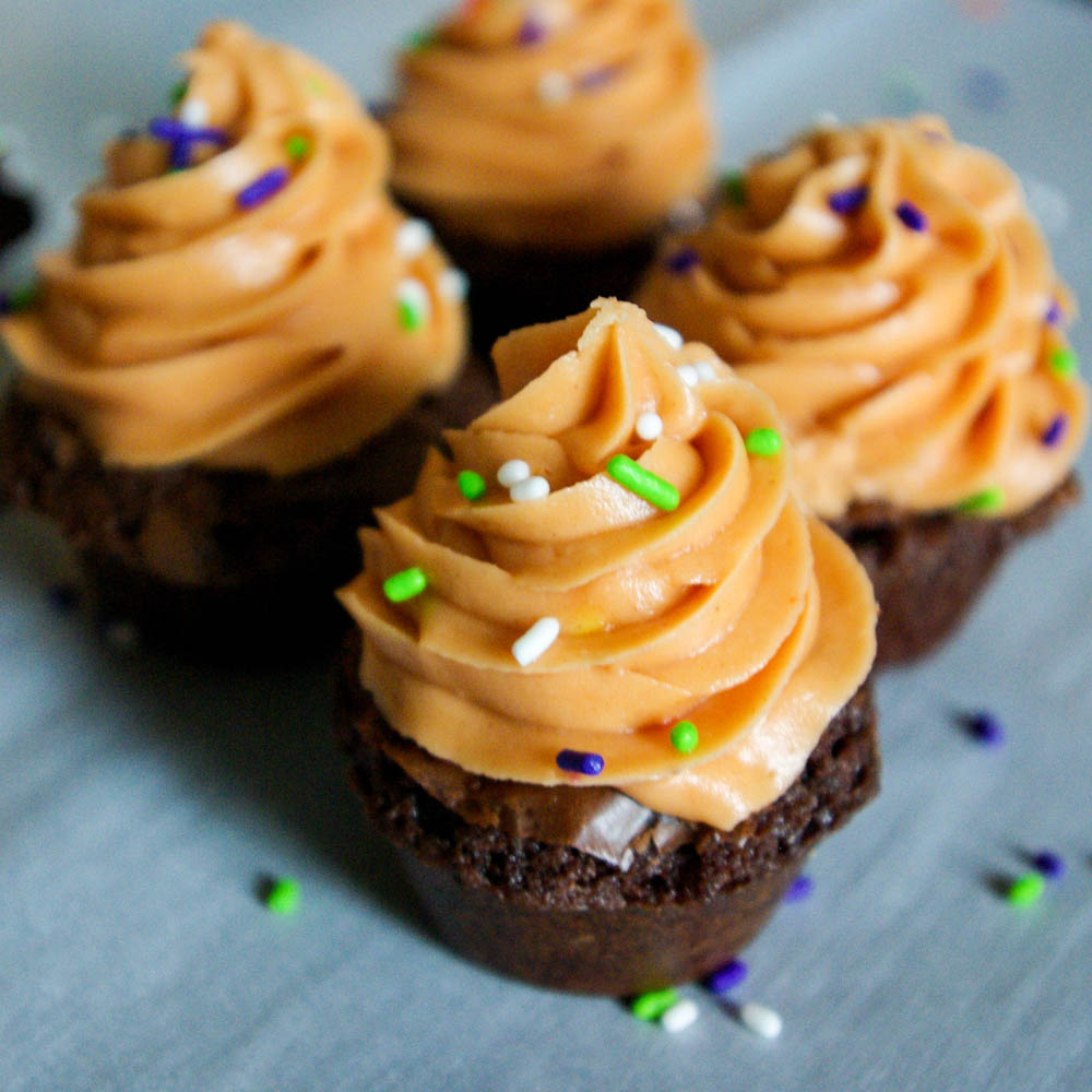 Butterfinger Crunch Brownie Cups - Butterfinger frosting made out of candy corn and peanut butter is a perfect Halloween treat #butterfinger #halloween #brownies | www.thebatterthickens.com