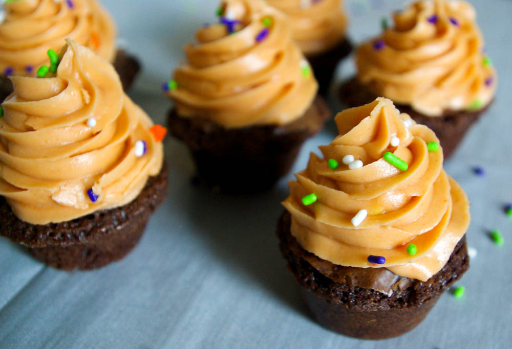 Butterfinger Crunch Brownie Cups - Butterfinger frosting made out of candy corn and peanut butter is a perfect Halloween treat #butterfinger #halloween #brownies | www.thebatterthickens.com