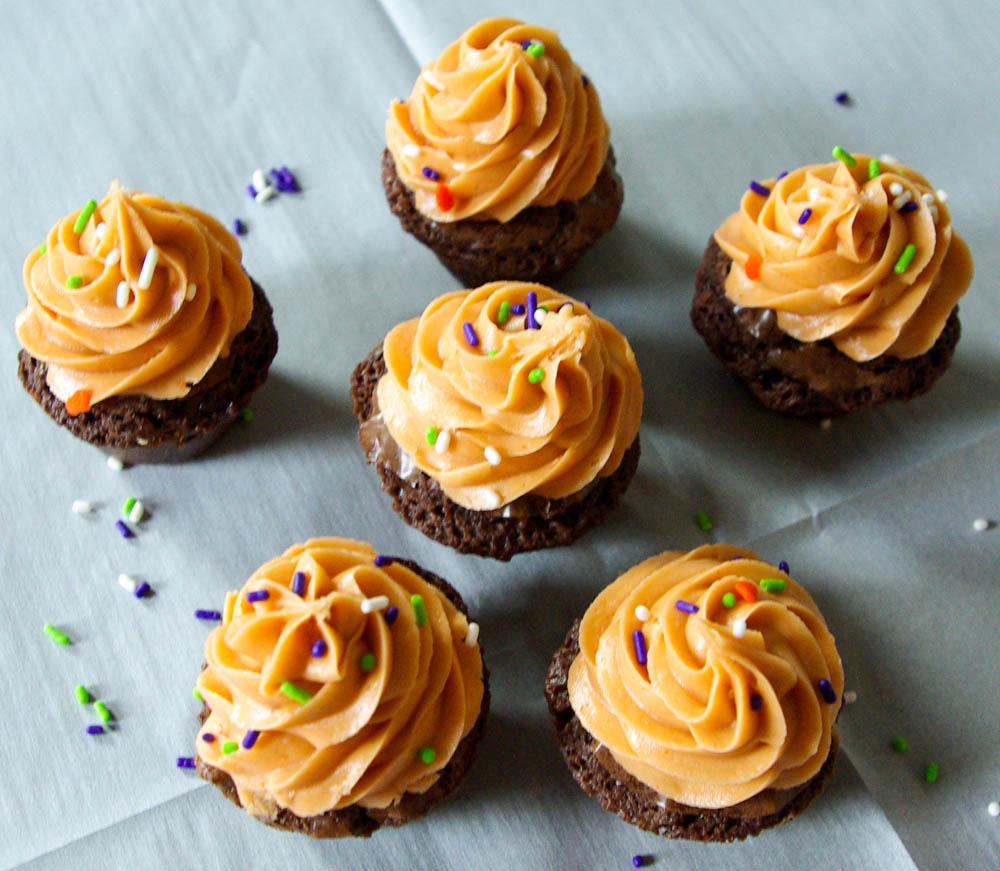 Butterfinger Crunch Brownie Cups - Butterfinger frosting made out of candy corn and peanut butter is a perfect Halloween treat #butterfinger #halloween #brownies | www.thebatterthickens.com