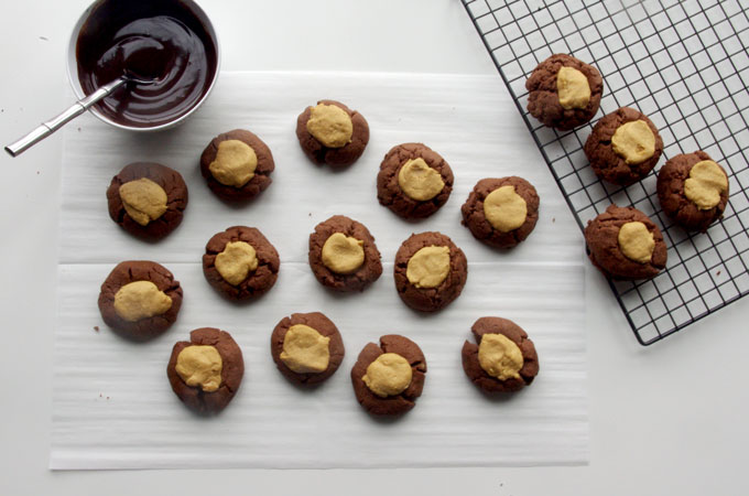 Buckeye Thumbprint Cookies - dense chocolate cookie base topped with a sweet peanut peanut butter ball and drizzled with bittersweet chocolate | www.thebatterthickens.com
