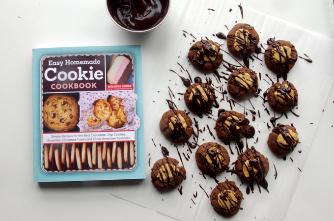 Buckeye Thumbprint Cookies - dense chocolate cookie base topped with a sweet peanut peanut butter ball and drizzled with bittersweet chocolate | www.thebatterthickens.com