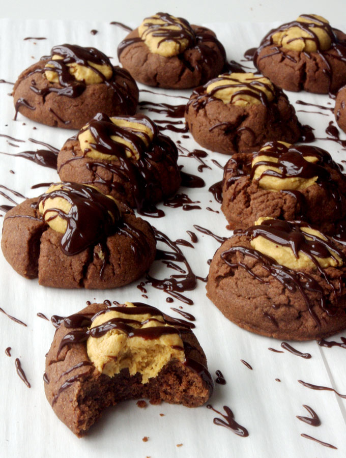 Buckeye Thumbprint Cookies - dense chocolate cookie base topped with a sweet peanut peanut butter ball and drizzled with bittersweet chocolate | www.thebatterthickens.com