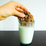 Ovaltine cookie being dunked into a cup of milk
