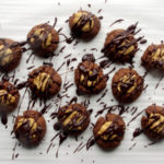 Buckeye Thumbprint Cookies - dense chocolate cookie base topped with a sweet peanut peanut butter ball and drizzled with bittersweet chocolate | www.thebatterthickens.com